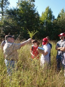 John Stucky explaining to students the significance of the plant species found on the site