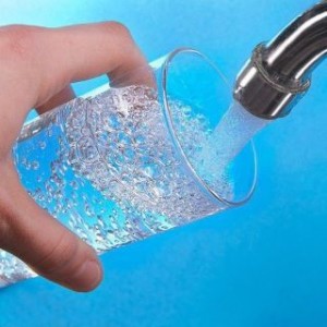 Clean water flowing from faucet to glass