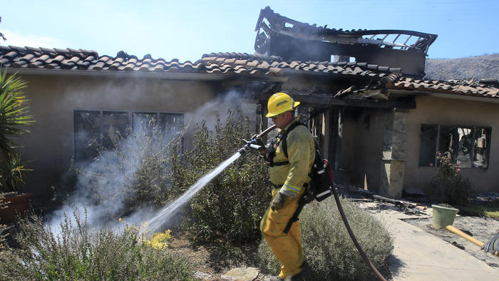 Firefighters douse final hotspots at David and Sherri Roberts home that was destroyed by fire 24-hours earlier on a hilltop in Escondido (LA Times)